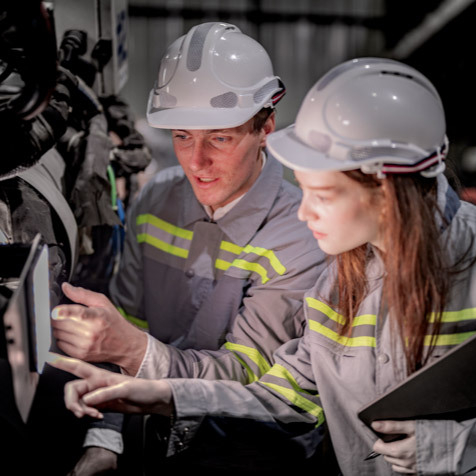 Two workers inspecting a machine for welding sales.
