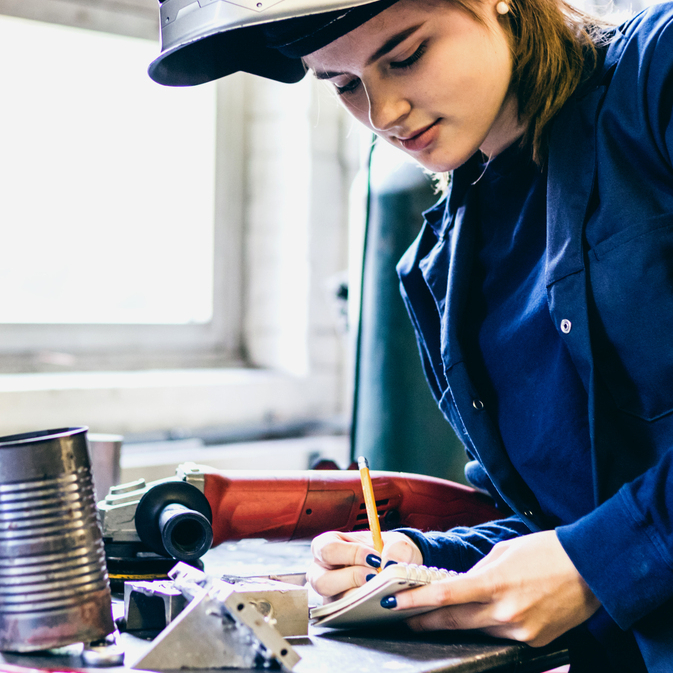 Welder writing down notes for her WPS